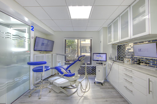 Modern dental operatory with a blue dental chair and white cabinetry at DC Implant & Cosmetic Dentistry in Washington, DC